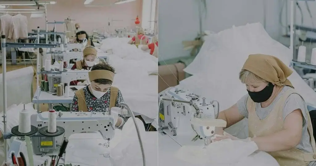 Grupo de empleadas trabajando en línea de producción dentro de un taller de costura industrial, operando máquinas de coser profesionales.