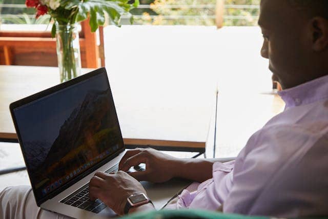 Freelancer de honduras concentrado trabajando desde casa en su laptop, ideal para profesiones digitales remotas