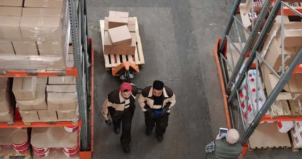 Materiales de empaque, cinta y cajas apiladas listas para ser ensambladas en un espacio de trabajo remoto.